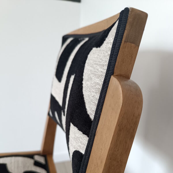 Chaise bois style art déco recouvert d'un tissu d'ameublement noir et blanc aux formes géométriques - vue dossier